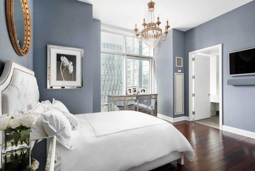 Bright bedroom with large windows and decor.